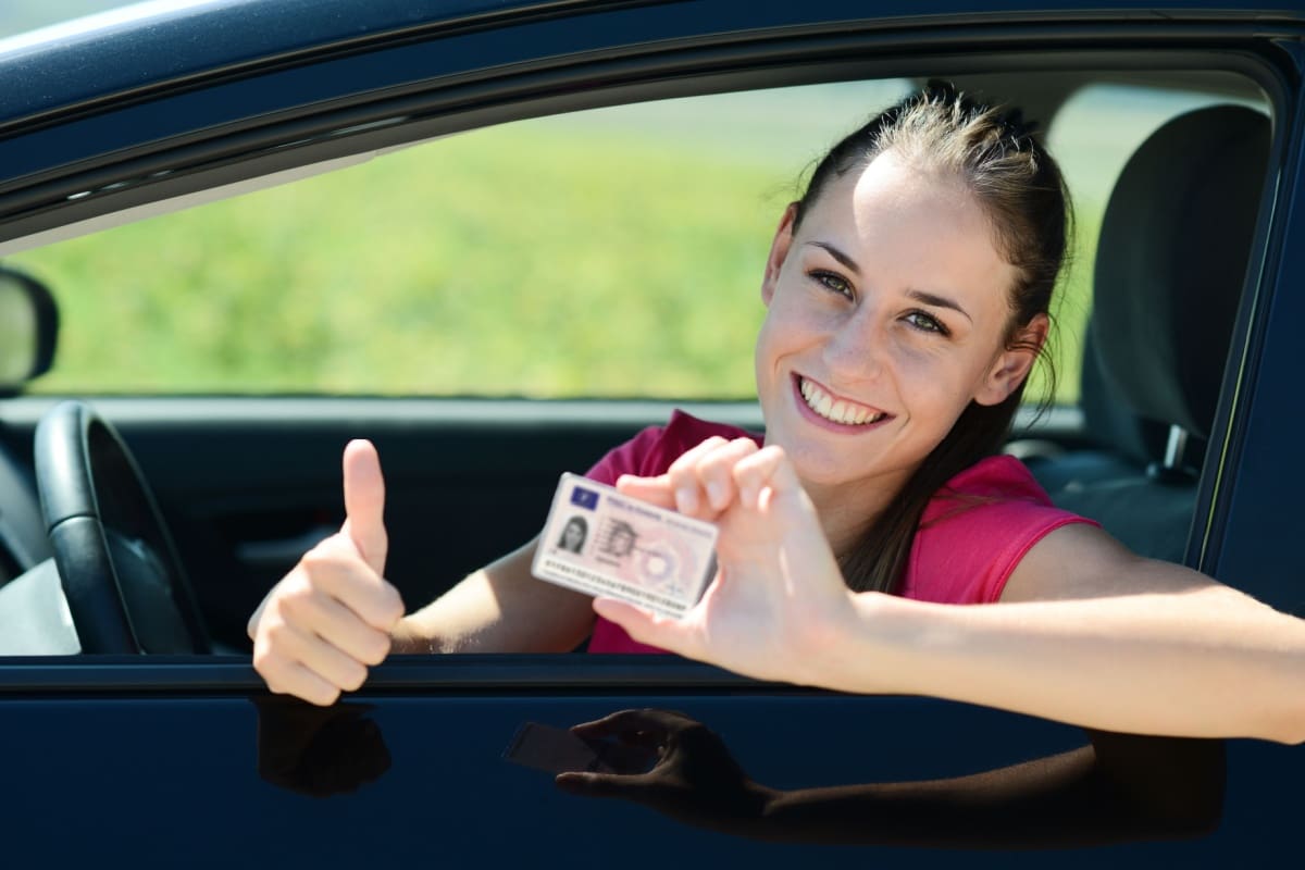 Happy driver showing her reinstated drivers license