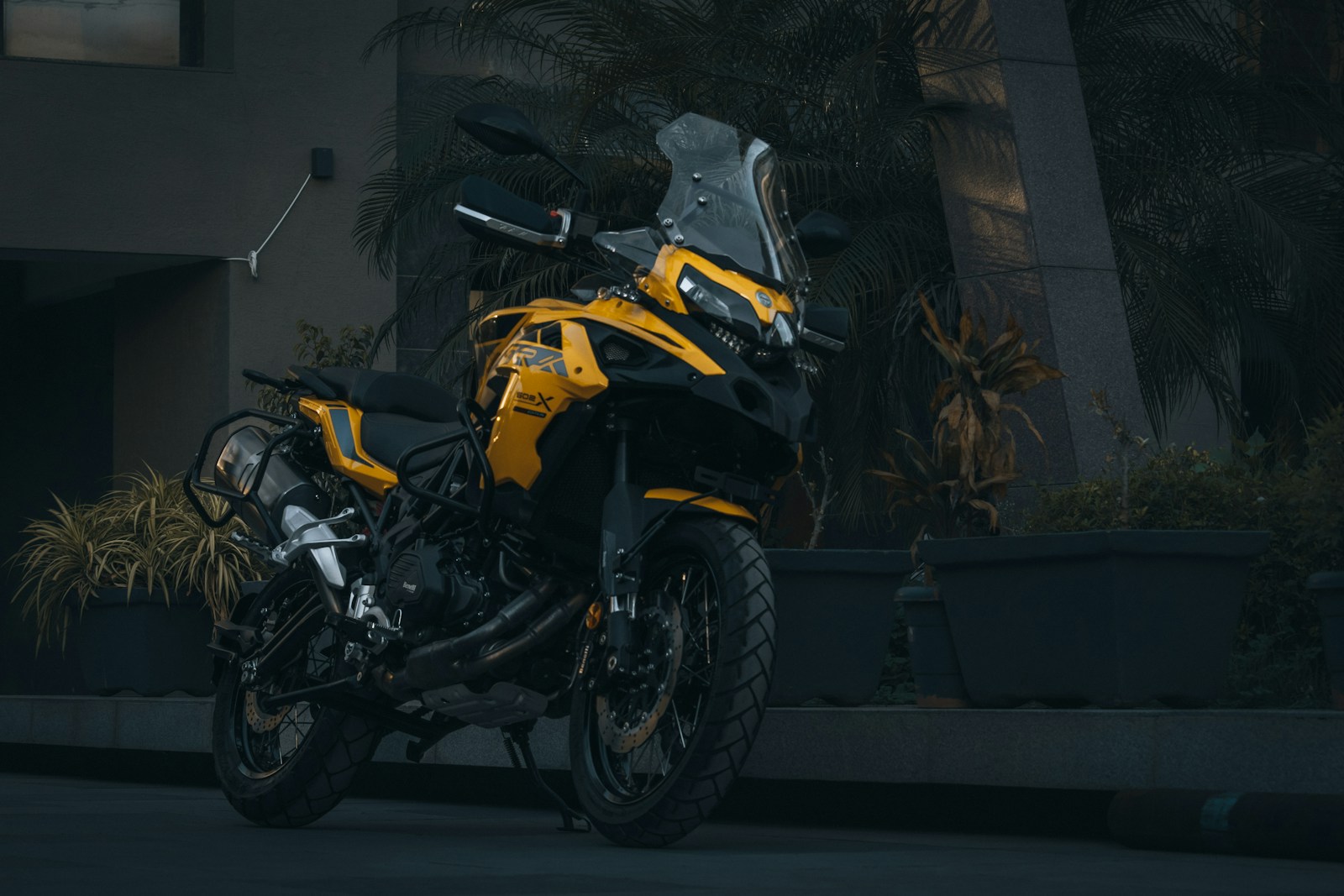 a yellow and black motorcycle parked in front of a building