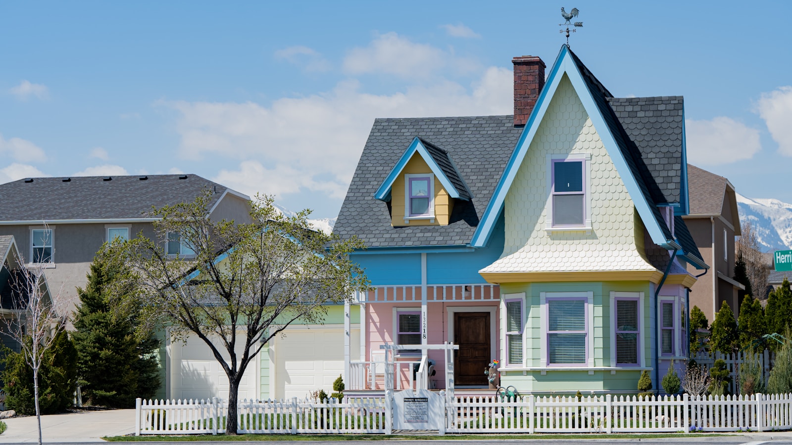 a multicolored house with a white picket fence