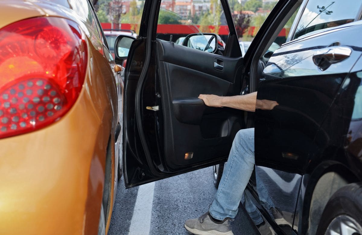 Person hitting another vehicle with a door